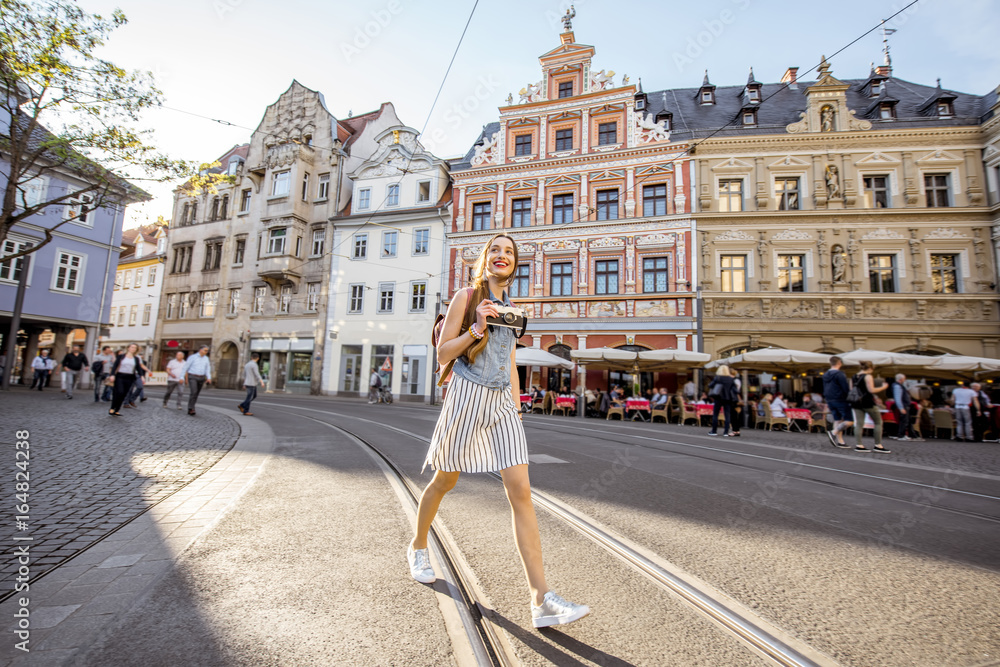一位年轻的女游客走在德国埃尔福特市老城区的街道上的肖像