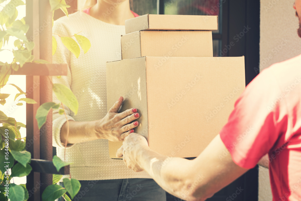 woman accepting a home delivery of boxes from delivery service courier