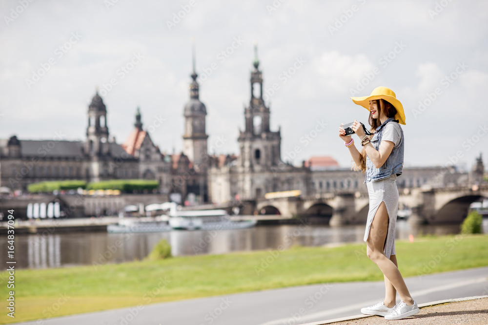 戴着黄帽子的年轻女游客在德国德累斯顿老城欣赏美景