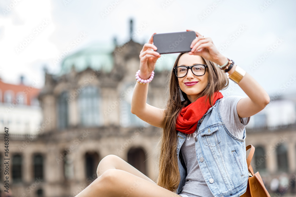 年轻时尚女性用手机拍摄德国德累斯顿古城