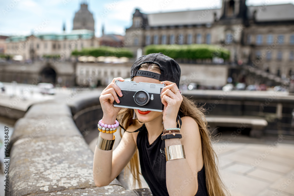 年轻的女游客带着相机，从德累斯顿老城的桥上欣赏美景