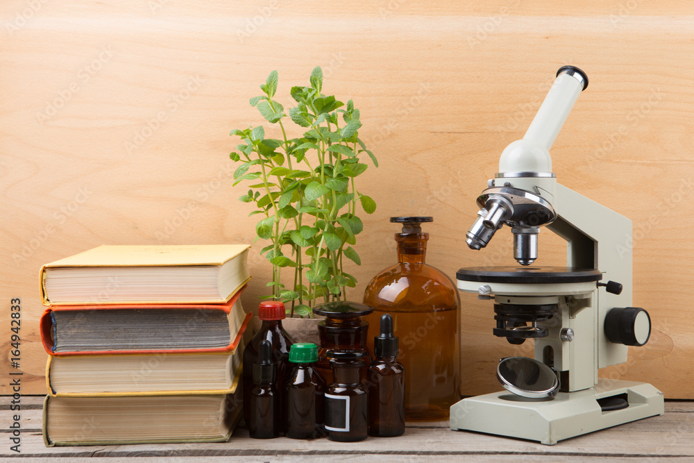 Medical education concept - microscope, books and pharmacy bottles