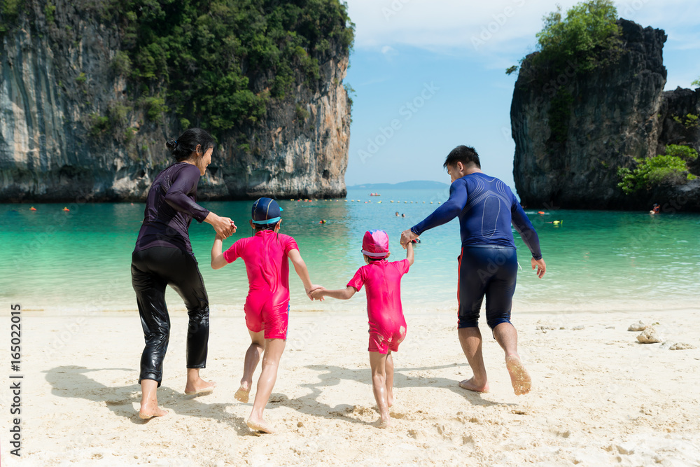 泰国普吉岛夏天，亚洲幸福家庭在海滩上奔跑的照片。夏天，旅行，弗吉尼亚州