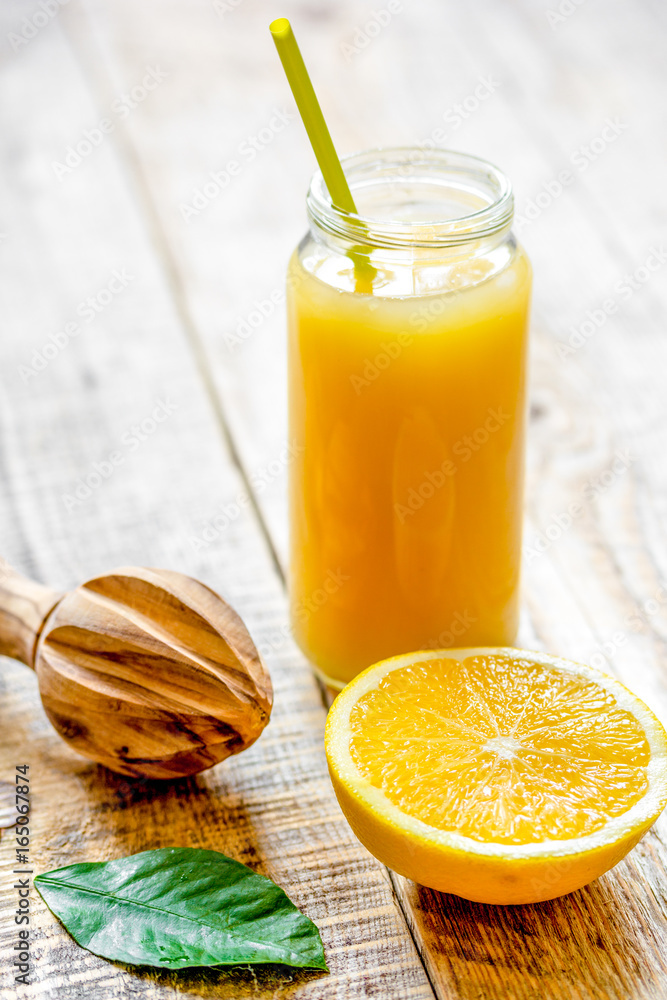 装在木制背板上的玻璃瓶中的鲜榨橙汁