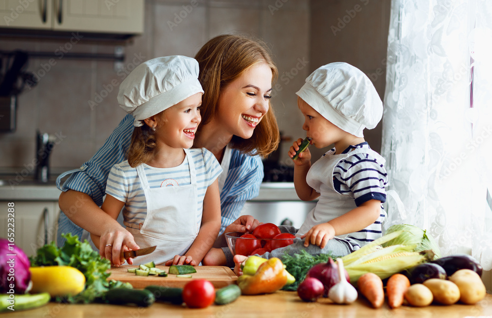健康饮食。快乐家庭妈妈和孩子准备蔬菜沙拉