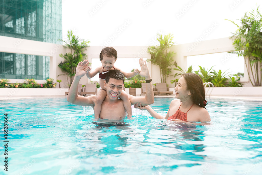 Happy family in swimming pool. Summer holidays and vacation concept