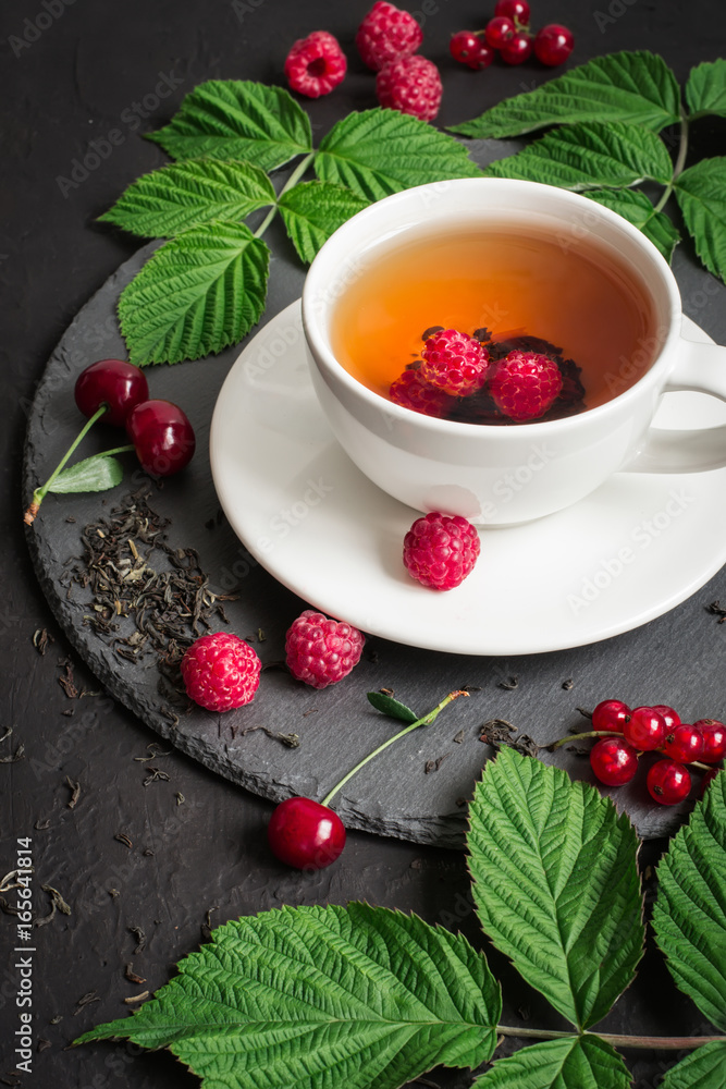 一杯浆果茶和成熟的树莓、樱桃、黑醋栗