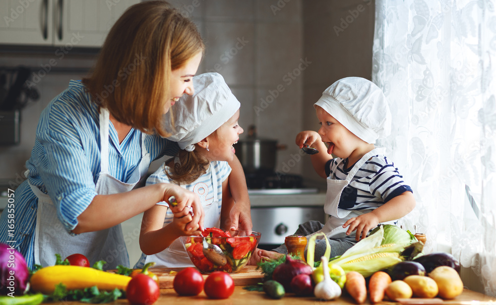 健康饮食。快乐家庭母亲和孩子准备蔬菜沙拉