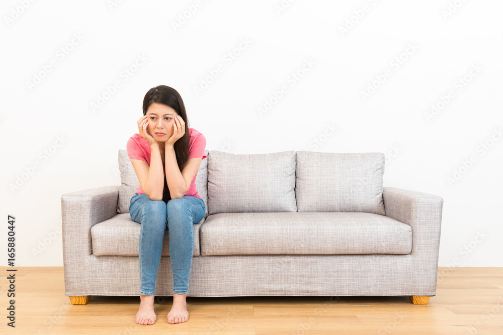悲伤的女人坐在沙发上哭泣
