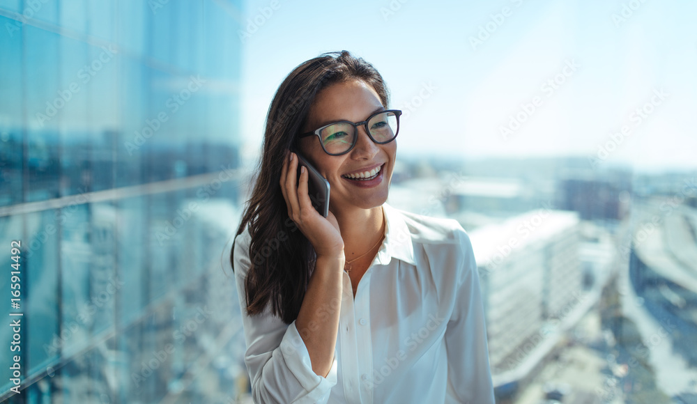 微笑的女企业家在电话里交谈。