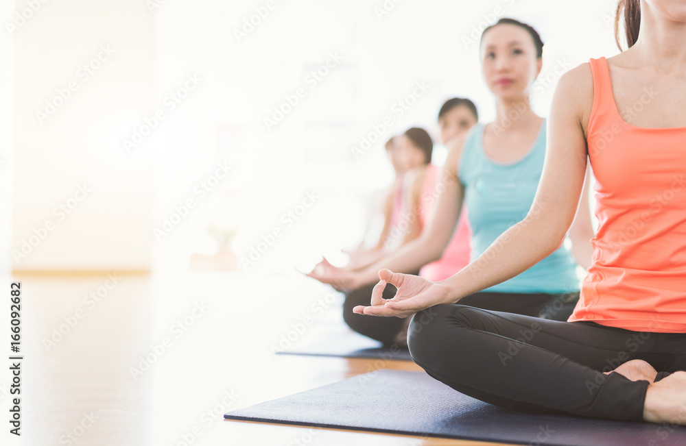 瑜伽时间到了。有魅力的年轻亚洲女子团体在y中锻炼和坐在瑜伽莲花姿势