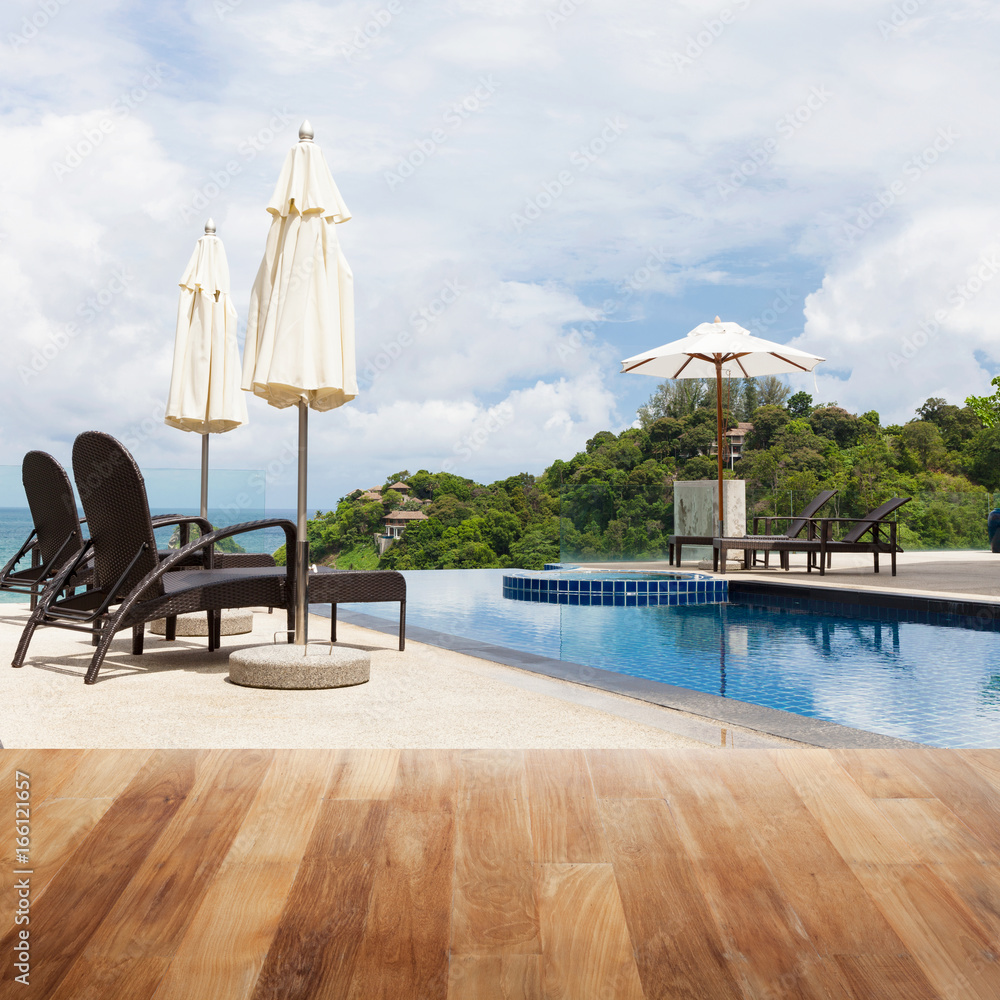 户外沙滩椅上的木桌面，带游泳池和安达曼海景。