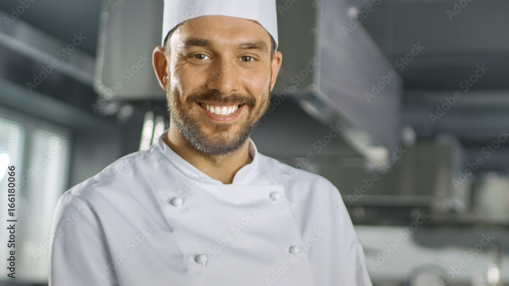 一位英俊的年轻厨师在慢镜头下微笑的肖像。浅景深拍摄。