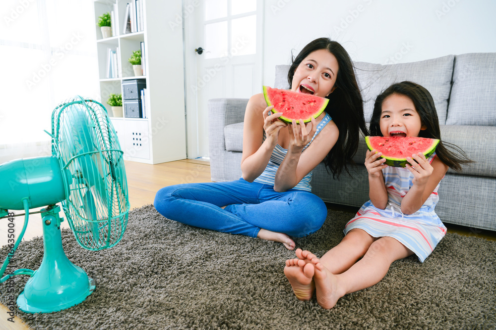 美丽的母亲带着女儿吃西瓜