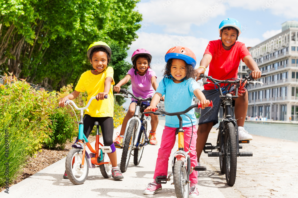 戴着头盔骑自行车的快乐非洲儿童