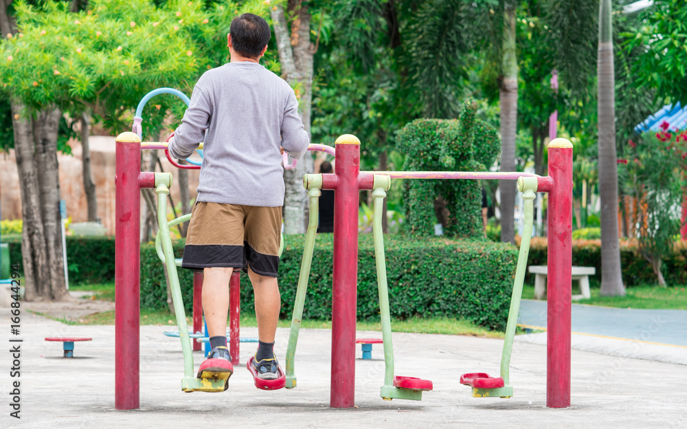 Asian adult man wear long sleeve shirt and shorts exercising outdoor at park in the morning