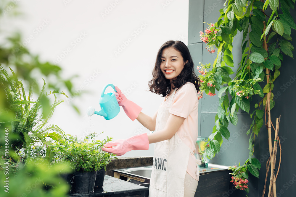 亚洲女园丁夏天在花园里浇花