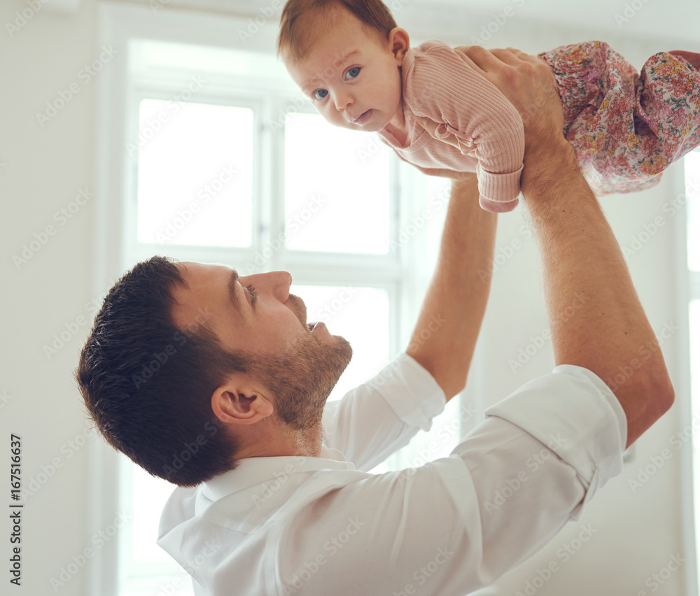 年轻的父亲把他的女婴举在空中