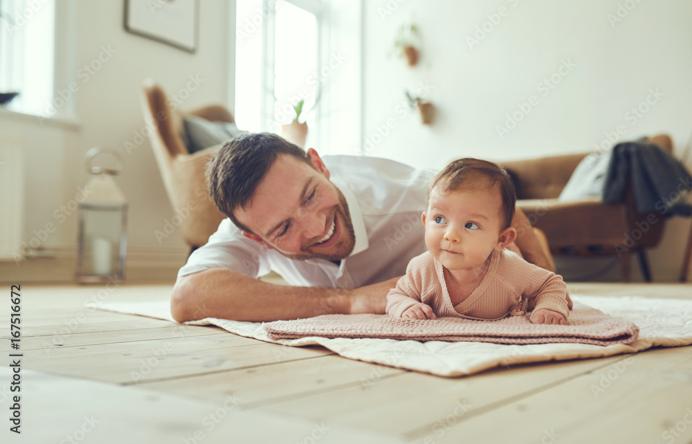 微笑的父亲带着年幼的女儿躺在家里