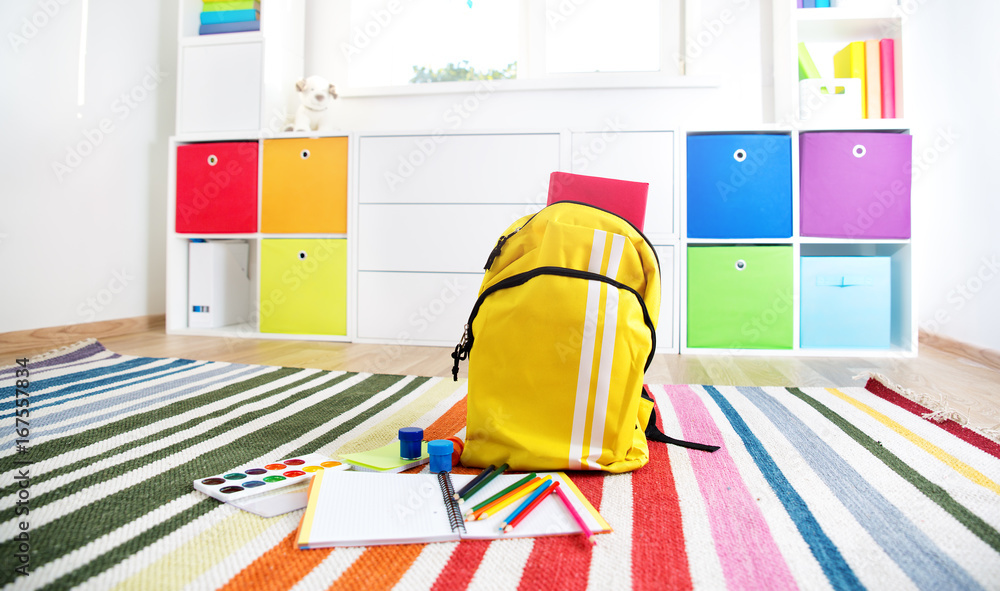 彩色儿童房，白色墙壁和家具。家里有彩虹地毯，有风