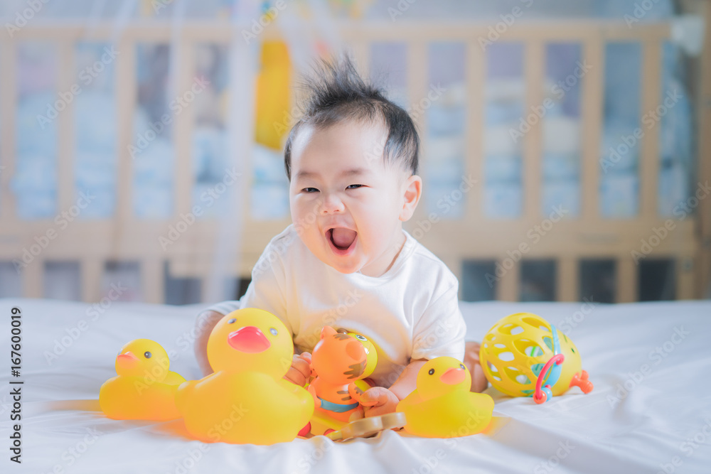 亚洲新生儿坐着玩动物玩具