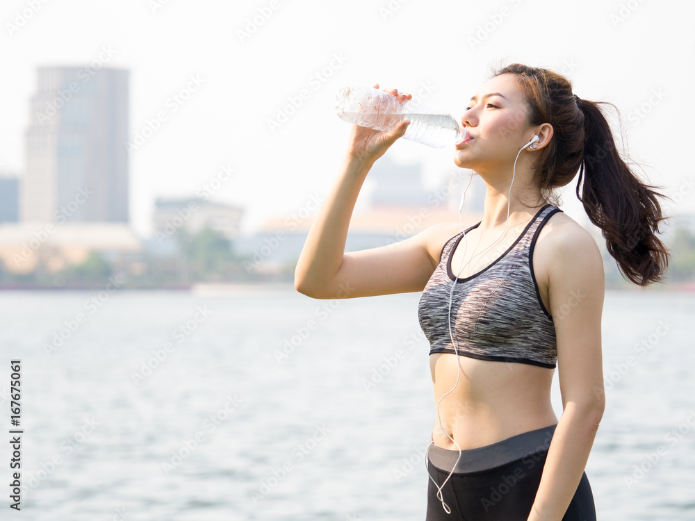 女性健身户外概念，年轻的亚洲美女在锻炼、跑步时喝水，j