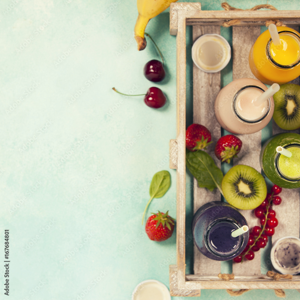 新鲜果汁或冰沙，配水果和蔬菜，装在蓝色背景的木托盘中