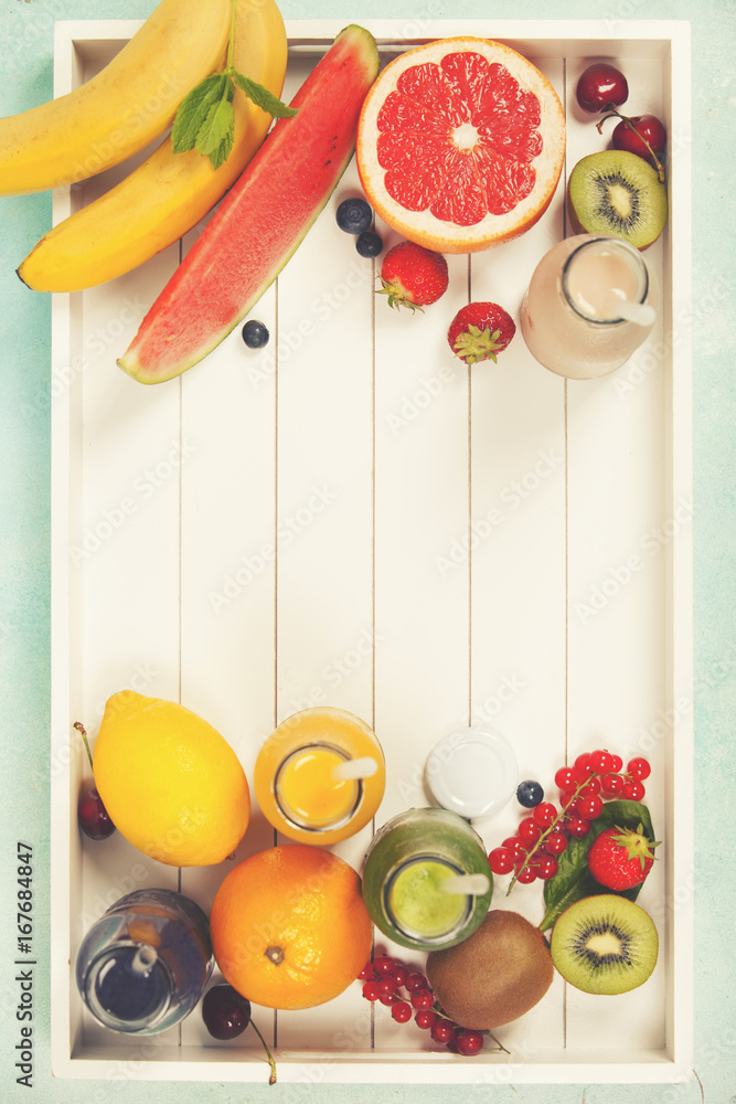 新鲜果汁或冰沙，配水果和蔬菜，装在蓝色背景的木托盘中