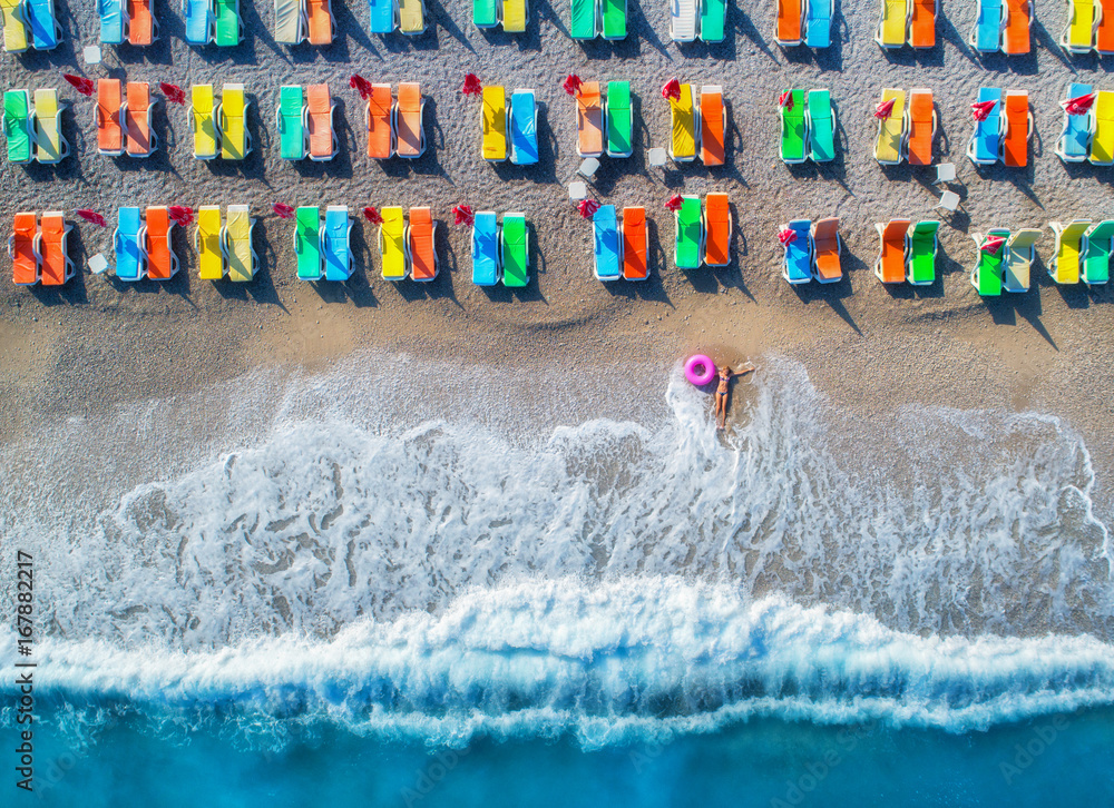 土耳其奥卢代尼兹，一位戴着游泳圈躺在海里的女士的鸟瞰图。与女孩的夏日海景，