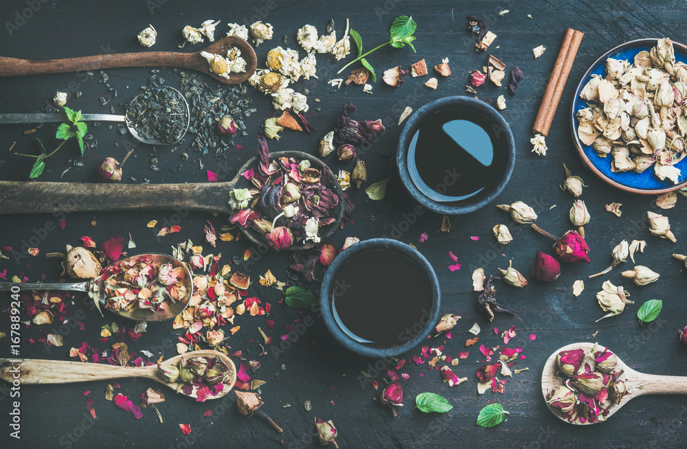 用干香草、花蕾和叶子制成的黑色石墙杯和木勺中的中国红茶