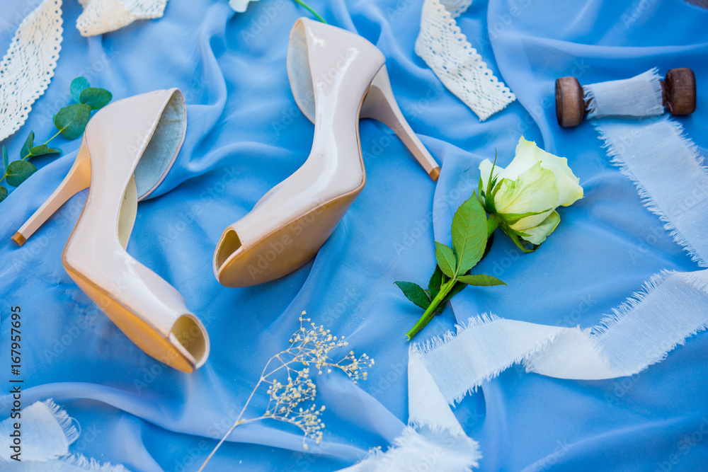 Wedding shoes. Footwear. Wedding accessories of the bride. Photo of a bride shoes on a blue backgrou
