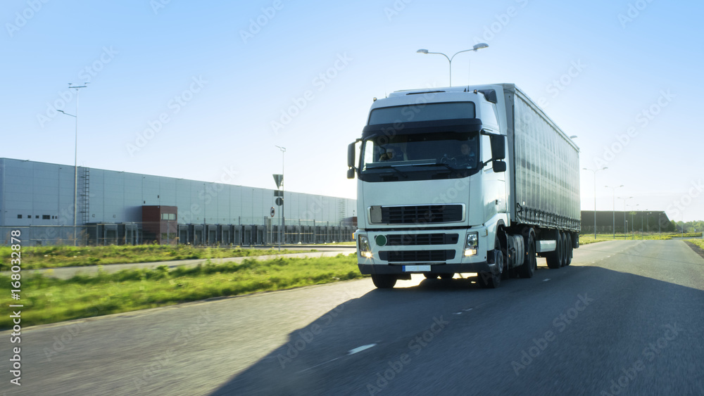 带货运拖车的半卡车在高速公路上行驶的前视图。他在工业W中行驶
