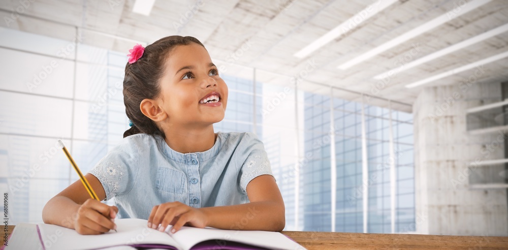 Composite image of girl looking up while sitting at desk