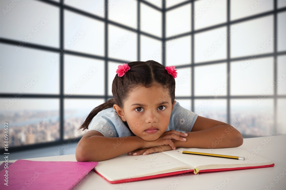 Composite image of girl leaning on open book at desk