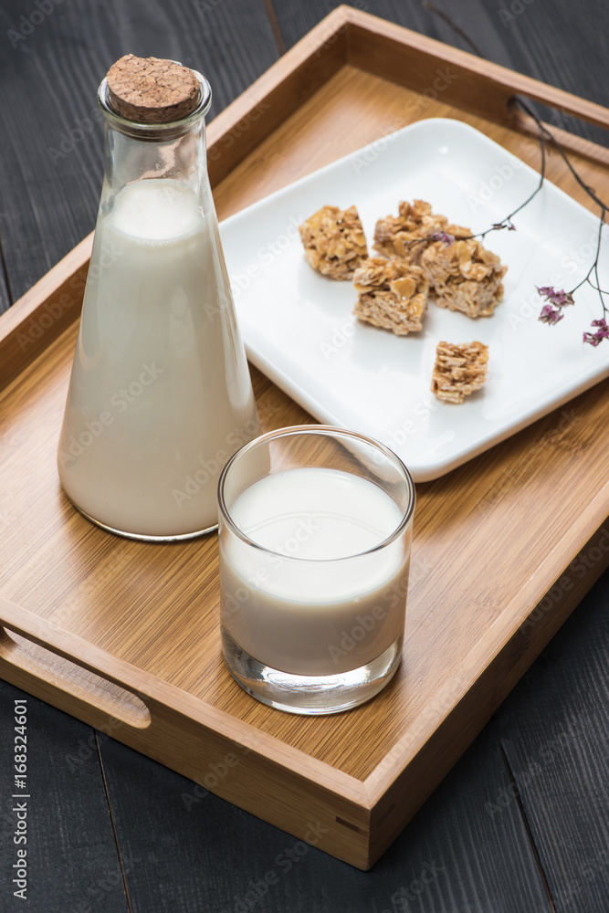 乳制品。一瓶牛奶和一杯牛奶配上乡村木桌上的杏仁糖