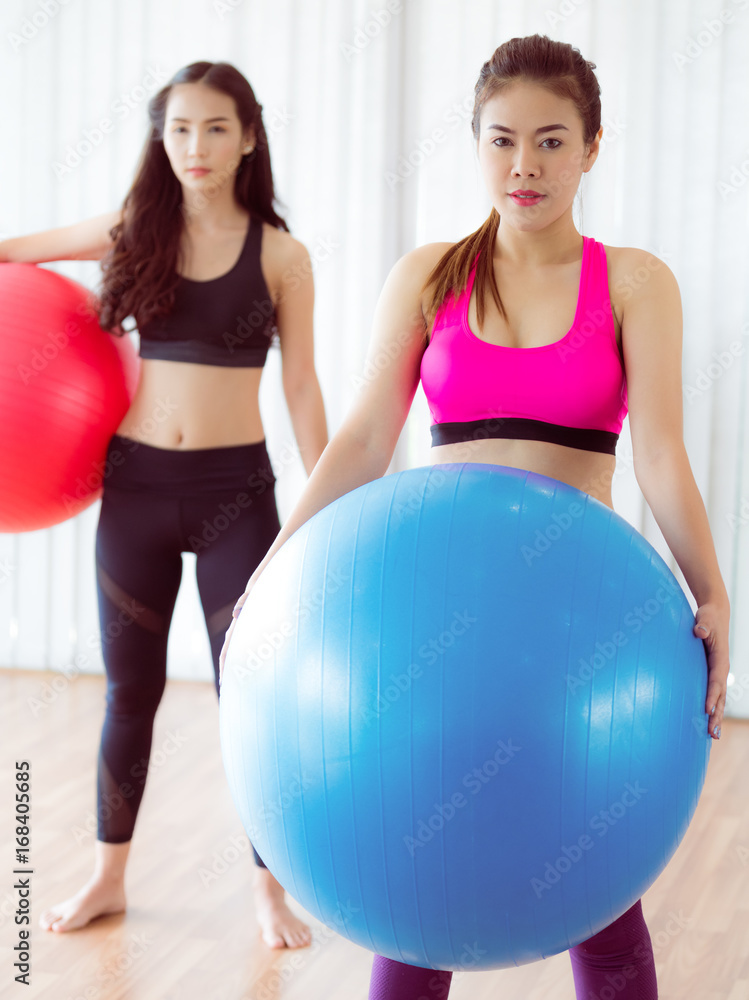 Women holding fit ball in fitness gym group class