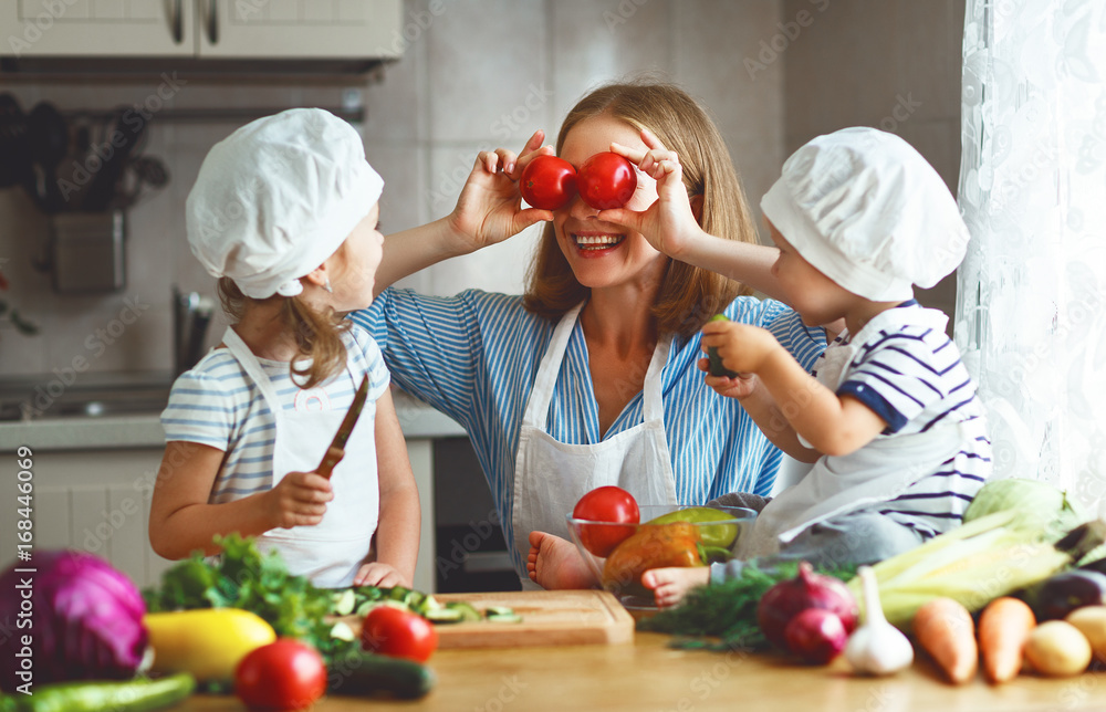 健康饮食。快乐家庭母亲和孩子准备蔬菜沙拉。