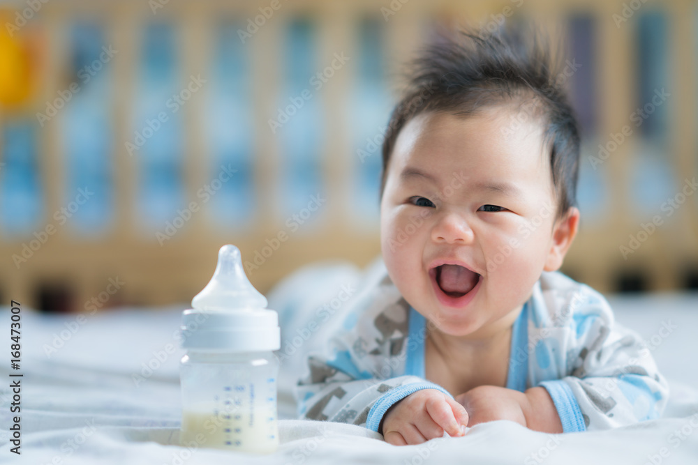 亚洲新生儿带着奶瓶微笑