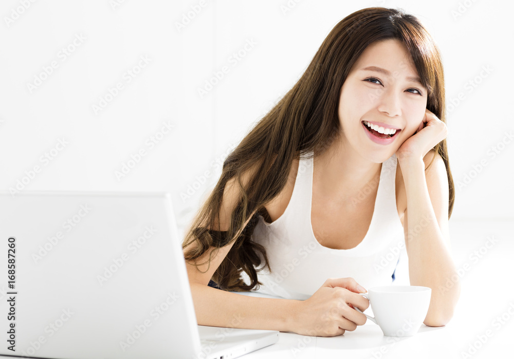 快乐的年轻漂亮女人用笔记本电脑。