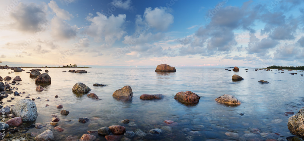 落日余晖下的海边岩石海岸。拉赫马自然公园海岸景观，天空美丽