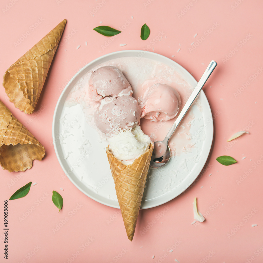 淡粉色草莓和椰子冰淇淋勺，白色盘子上的甜华夫饼蛋卷