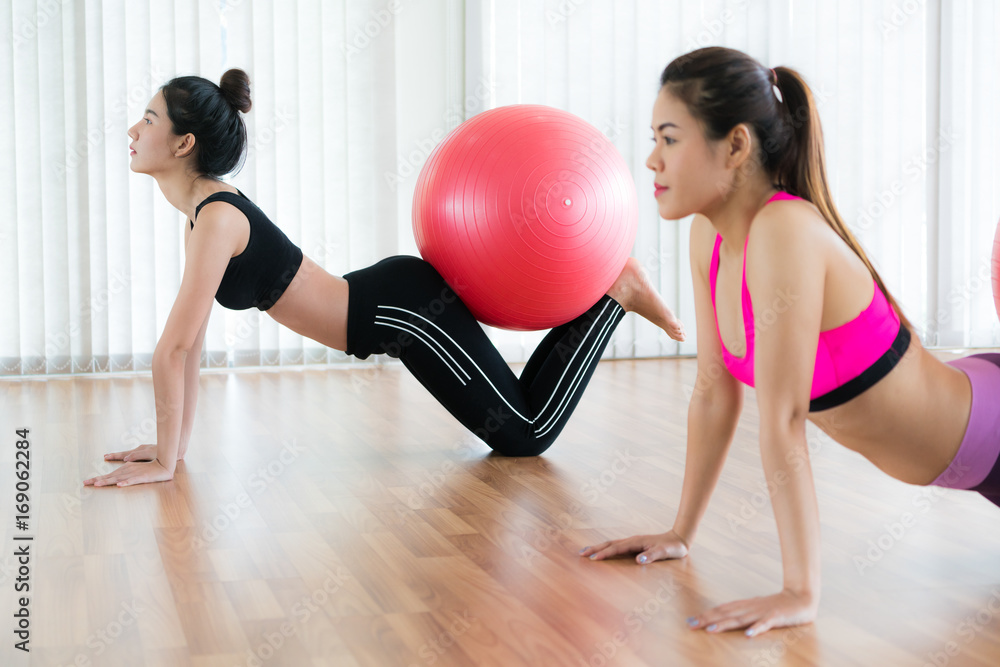 女性在健身课上用健身球锻炼