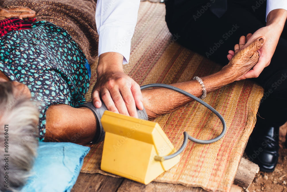 Male Doctor listening heart beat and breathing of Elderly Woman with Stethoscope with First Aid Medi