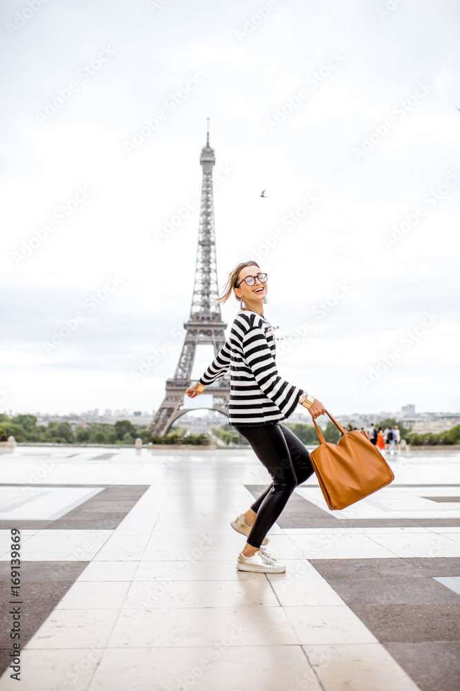 一位时尚女性在著名广场上跳跃的生活方式肖像，背后有埃菲尔铁塔