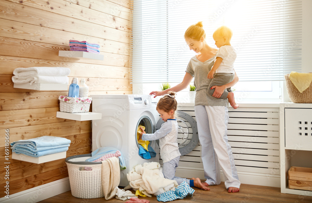 幸福的家庭母亲家庭主妇和孩子在洗衣机负载洗衣机