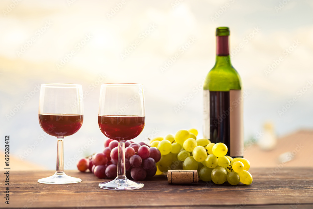 两杯红酒，葡萄，木桌上的瓶子