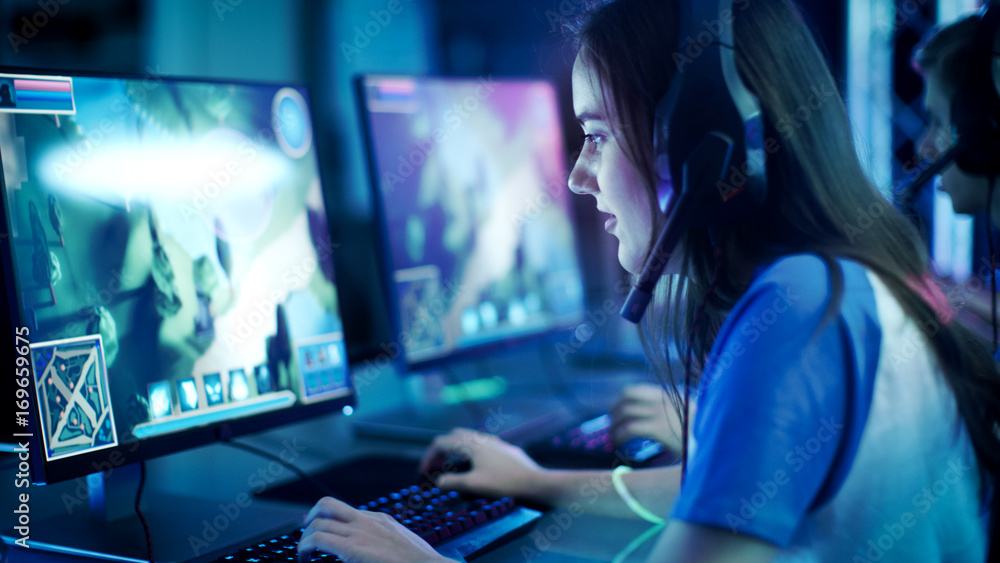 职业女玩家在电脑上玩MMORPG/战略电子游戏。她正在参与