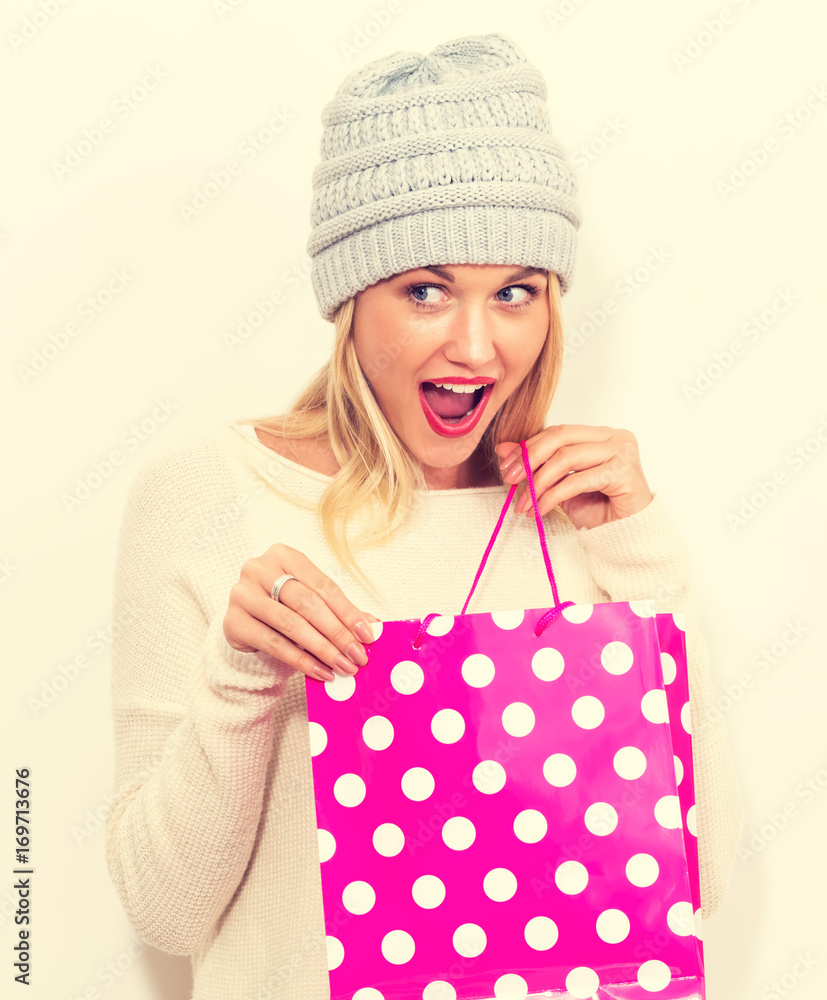 快乐的年轻女人拿着白色背景的购物袋