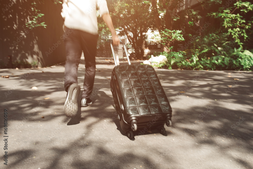 Motion blur of Young man and traveling luggage suitcase walking