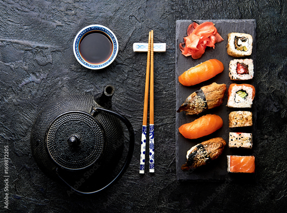 石桌上寿司和卷的变体。寿司卷，带筷子的生鱼片。俯视图
